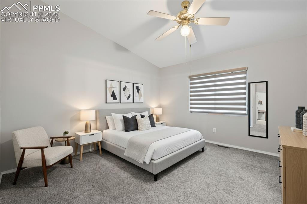 Master bedroom with attached bathroom. Features custom window treatments, ceiling fan. This photo is virtually staged.