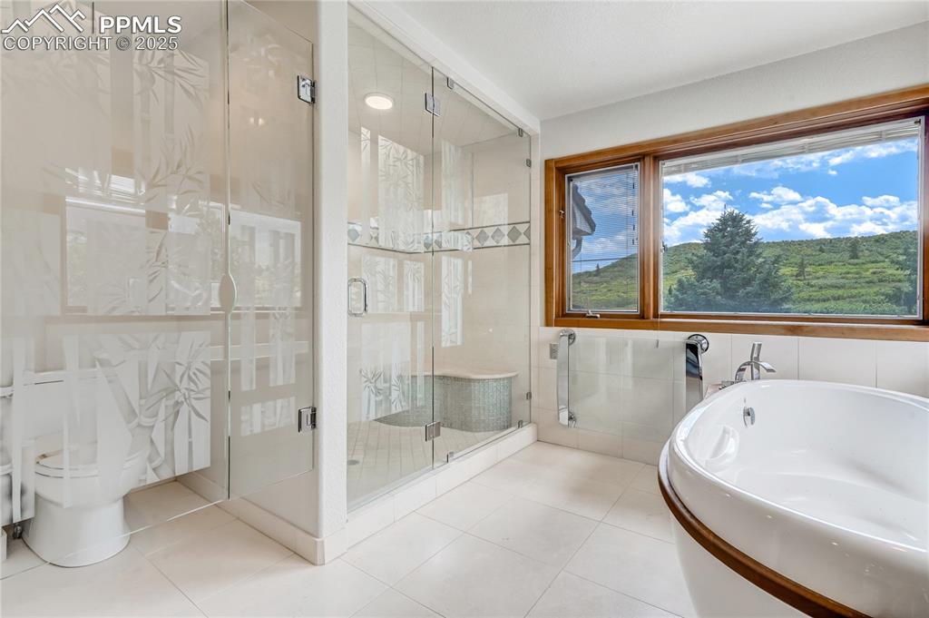 Bathroom with a shower stall, a bath, tile walls, and tile patterned floors