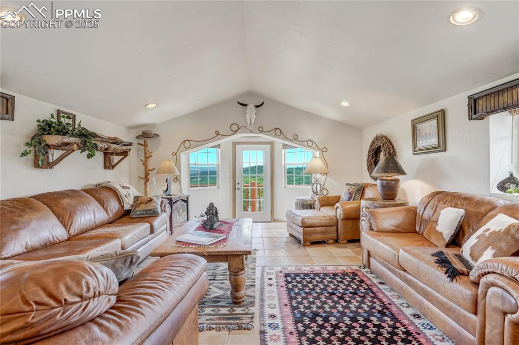 Living area featuring recessed lighting, light tile patterned flooring, and lofted ceiling