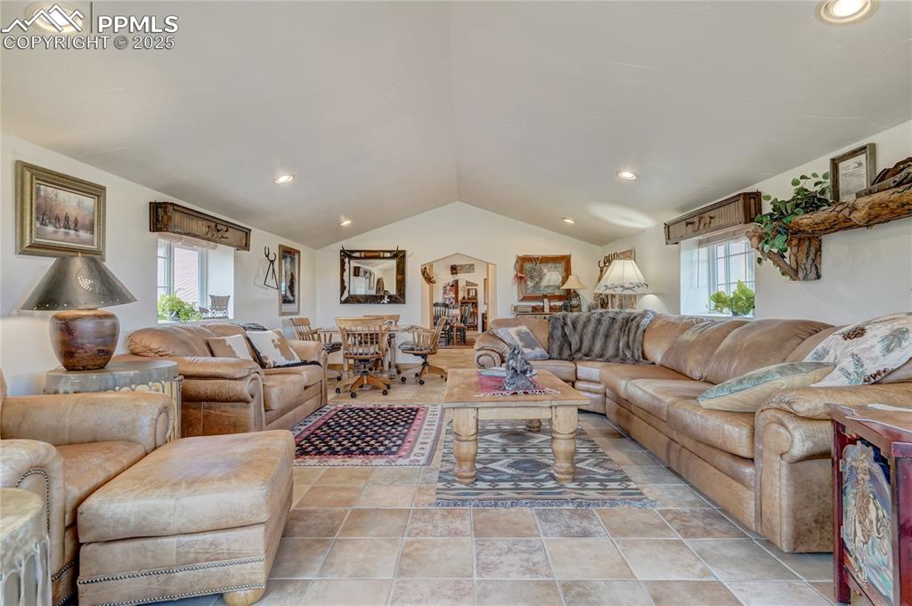 Living room with lofted ceiling and recessed lighting