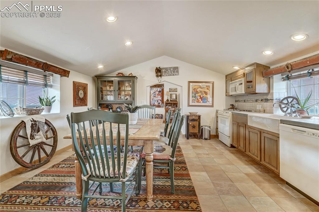Dining space with vaulted ceiling, recessed lighting, and light tile patterned floors