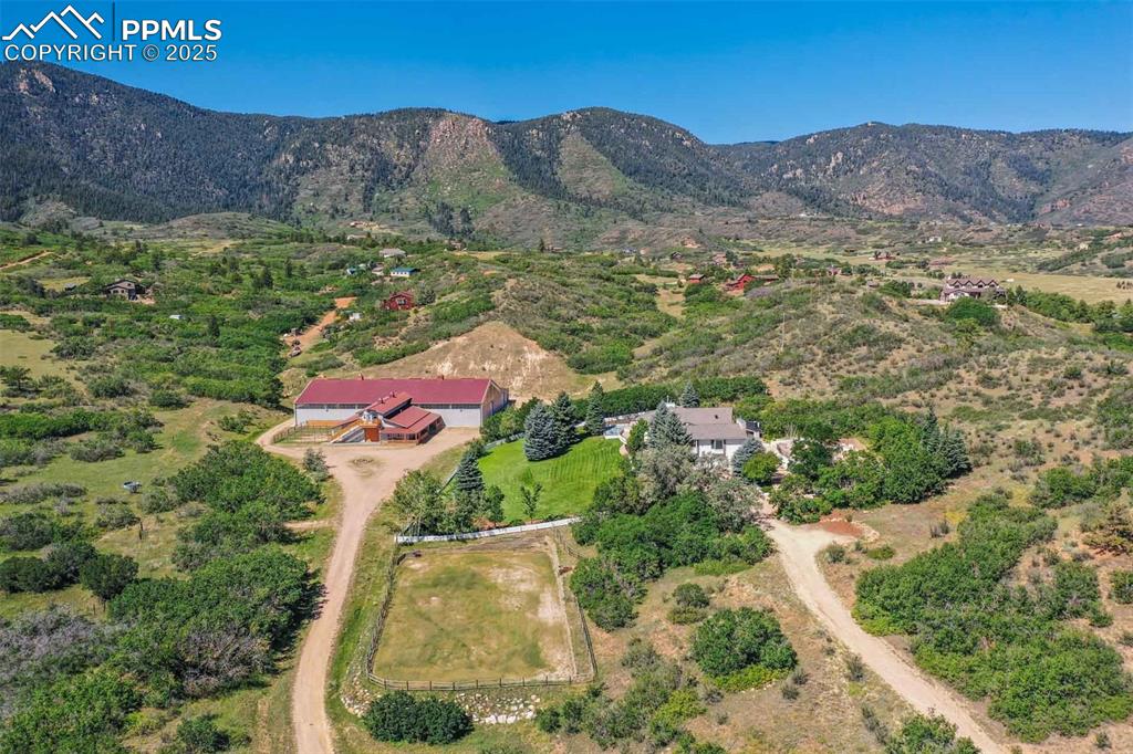 Aerial view of property and surrounding area featuring a mountainous background