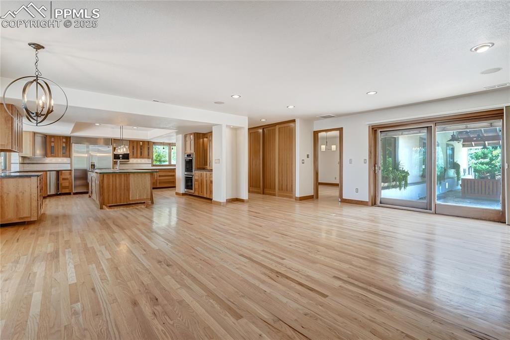 Kitchen with a kitchen island, a chandelier, light wood-type flooring, open floor plan, and recessed lighting