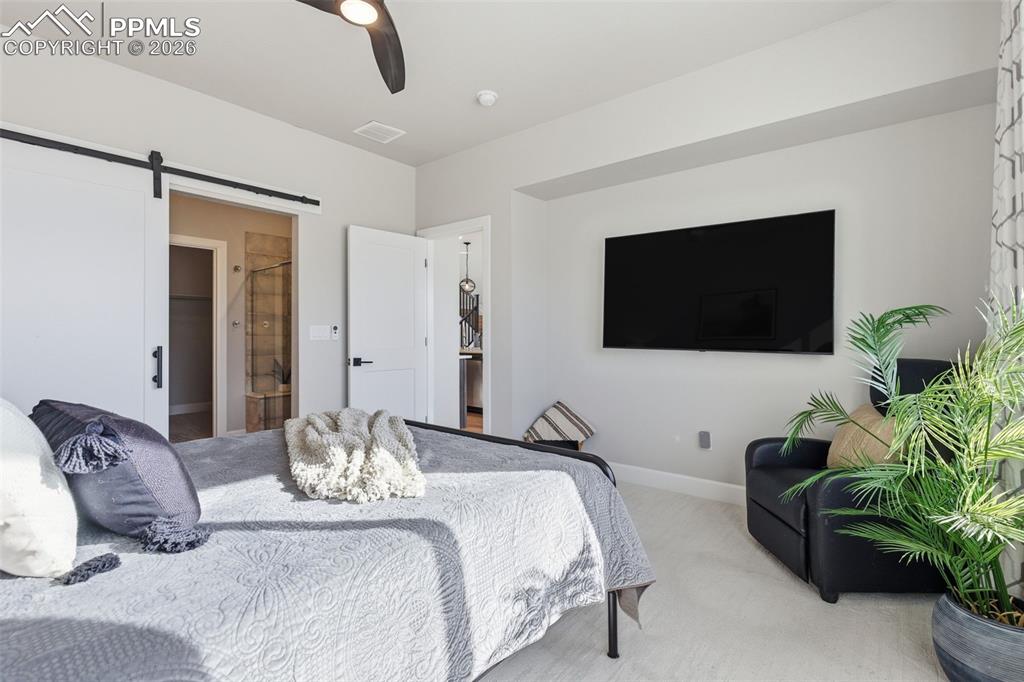 Owners' Suite off of the great room with barn door separating the spa-like bath