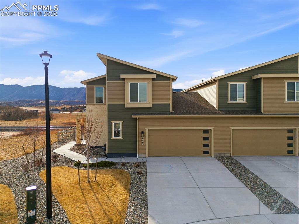 View of front of home featuring driveway, a mountain view, and a garage