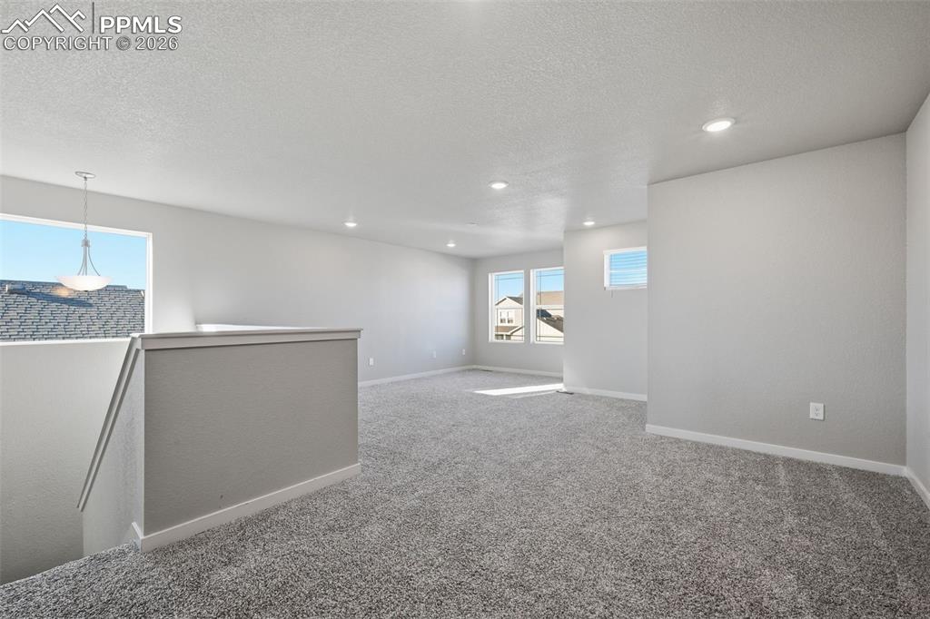 Spare room with a textured ceiling, light carpet, and recessed lighting