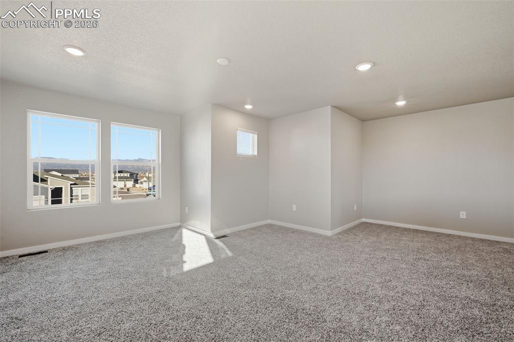 Unfurnished room with carpet flooring, a textured ceiling, and recessed lighting