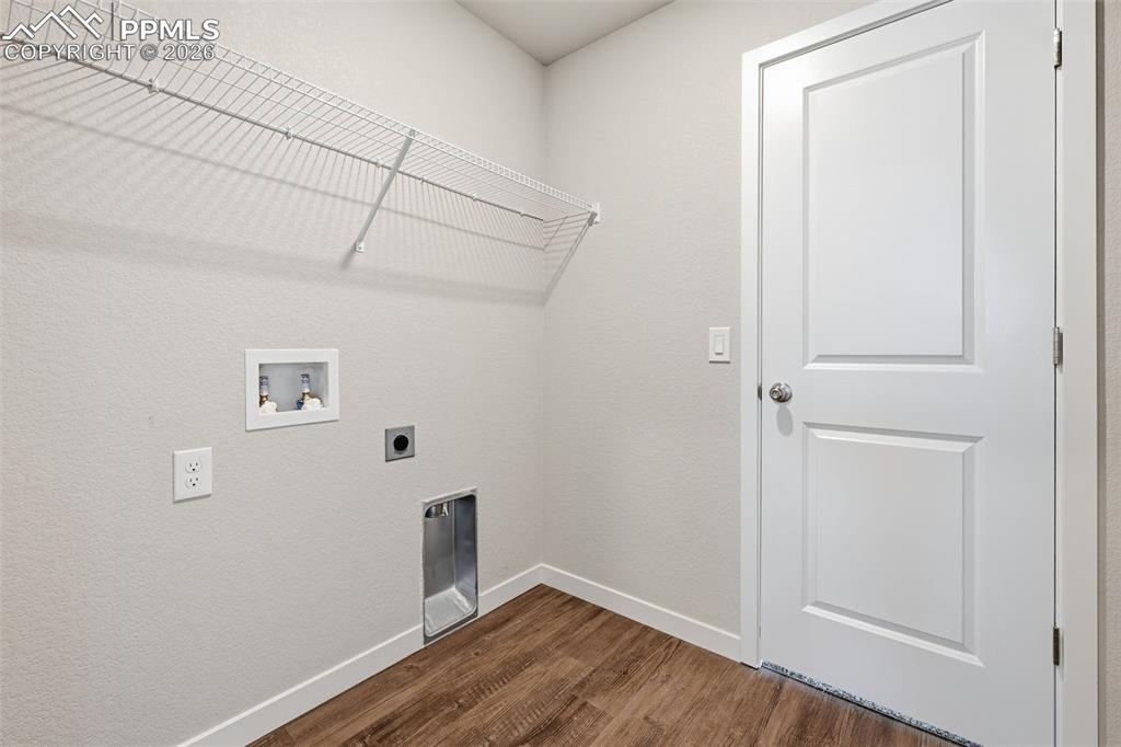 Laundry room with hookup for an electric dryer, dark wood-type flooring, washer hookup, and a textured wall
