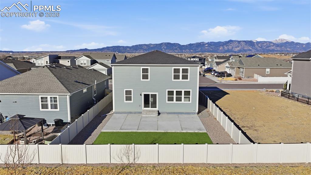 Rear view of property featuring a residential view, a fenced backyard, and a mountain view