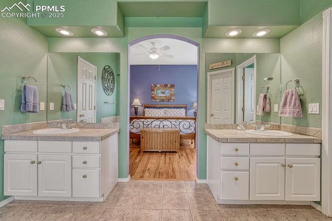 Bathroom featuring a stall shower, a bath, and dual vanities