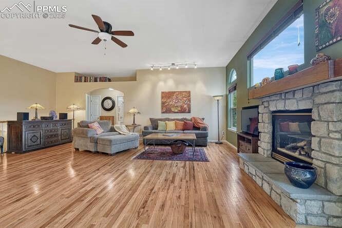 Living area with wood floors, a stone fireplace