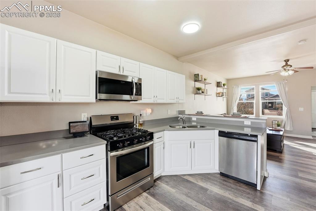 Kitchen with stainless steel appliances, white cabinets, and a peninsula