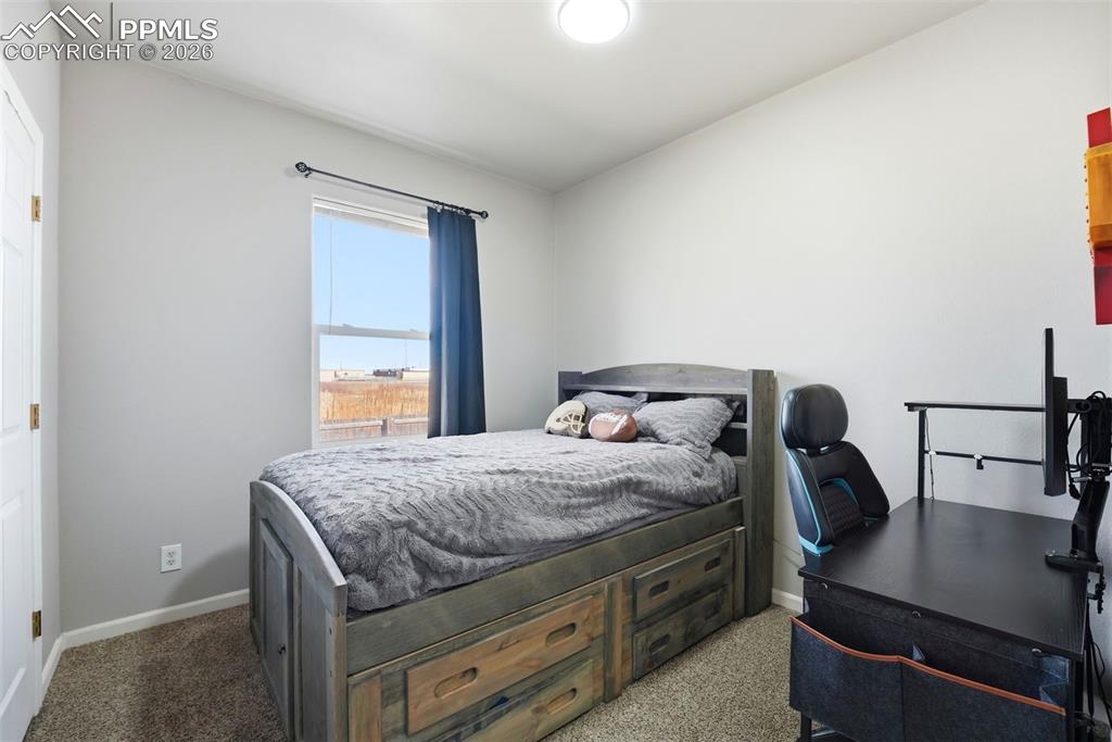 Bedroom featuring a desk and light carpet