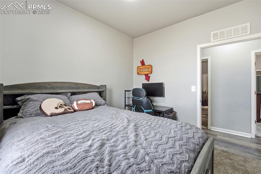 Bedroom featuring dark wood-type flooring and baseboards