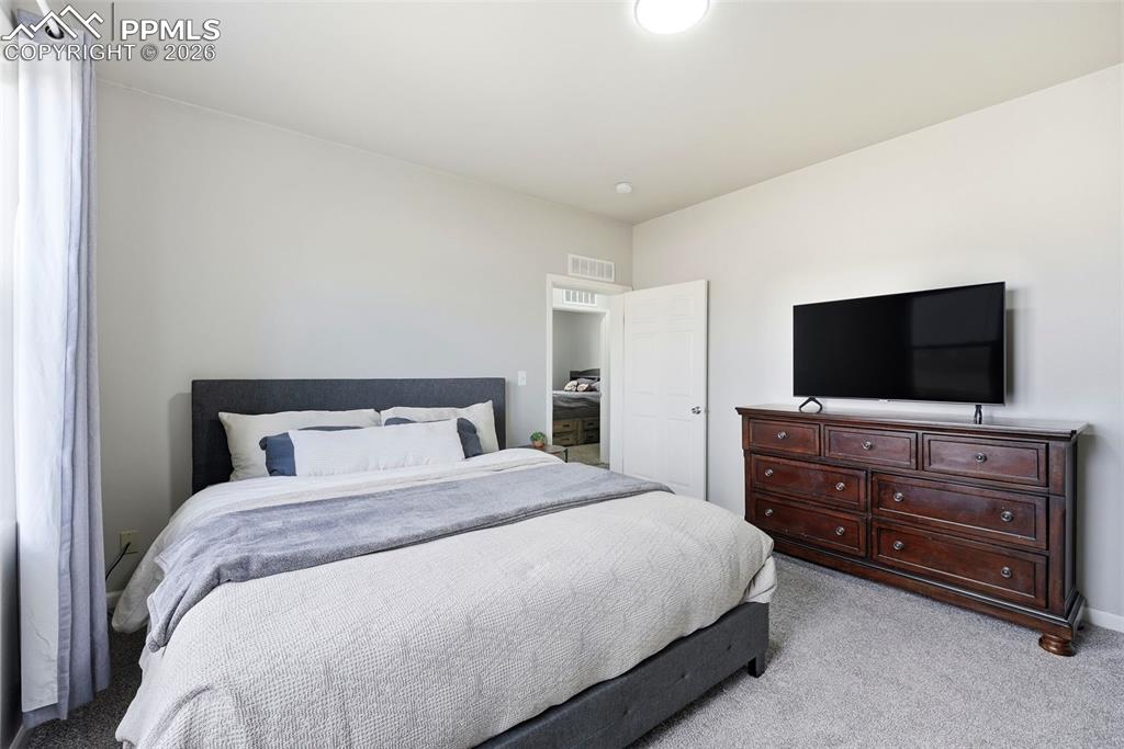 Bedroom featuring light carpet
