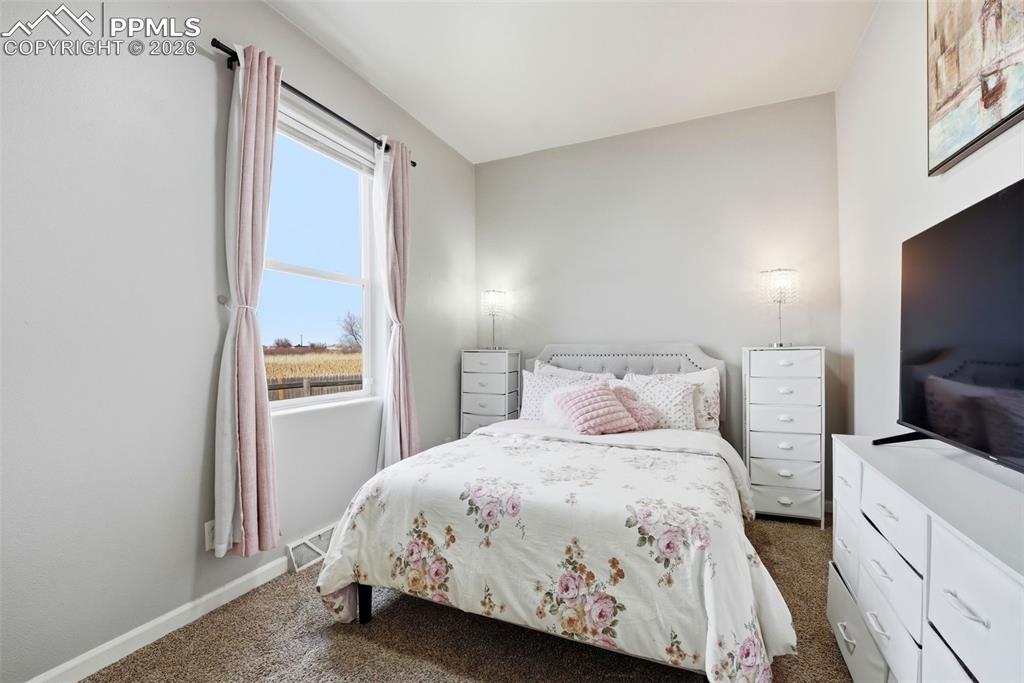 Bedroom featuring dark colored carpet and baseboards