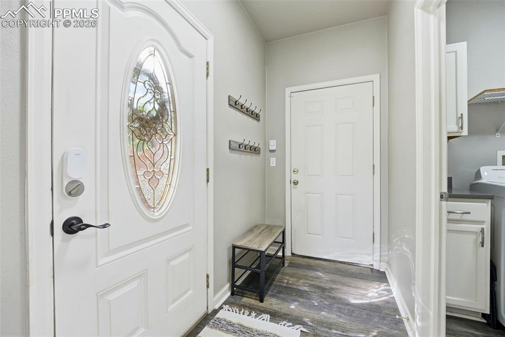 Entryway with washer / dryer and dark wood-type flooring