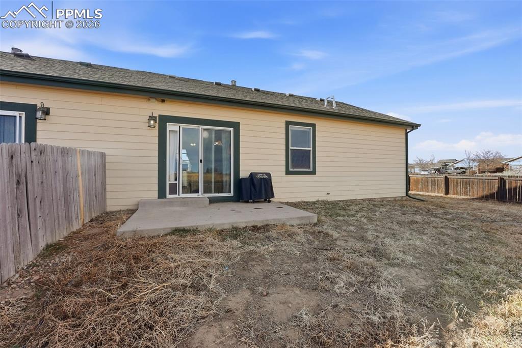 Rear view of property featuring a patio area and a fenced backyard