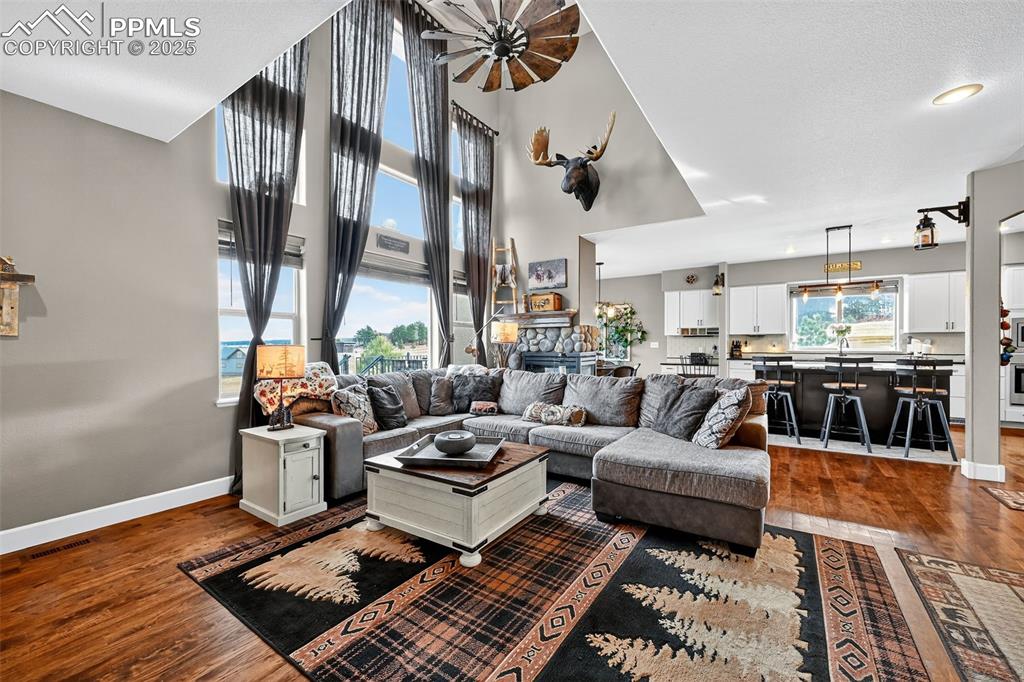 Living area featuring dark wood-type flooring and a towering ceiling