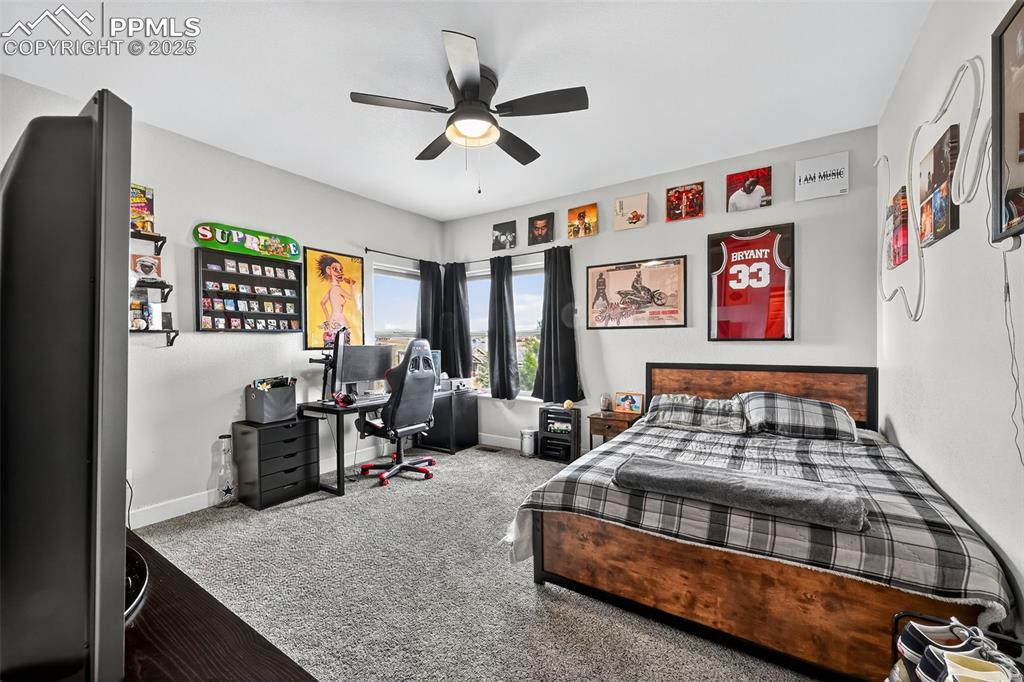 Bedroom featuring carpet floors, a ceiling fan, and a desk