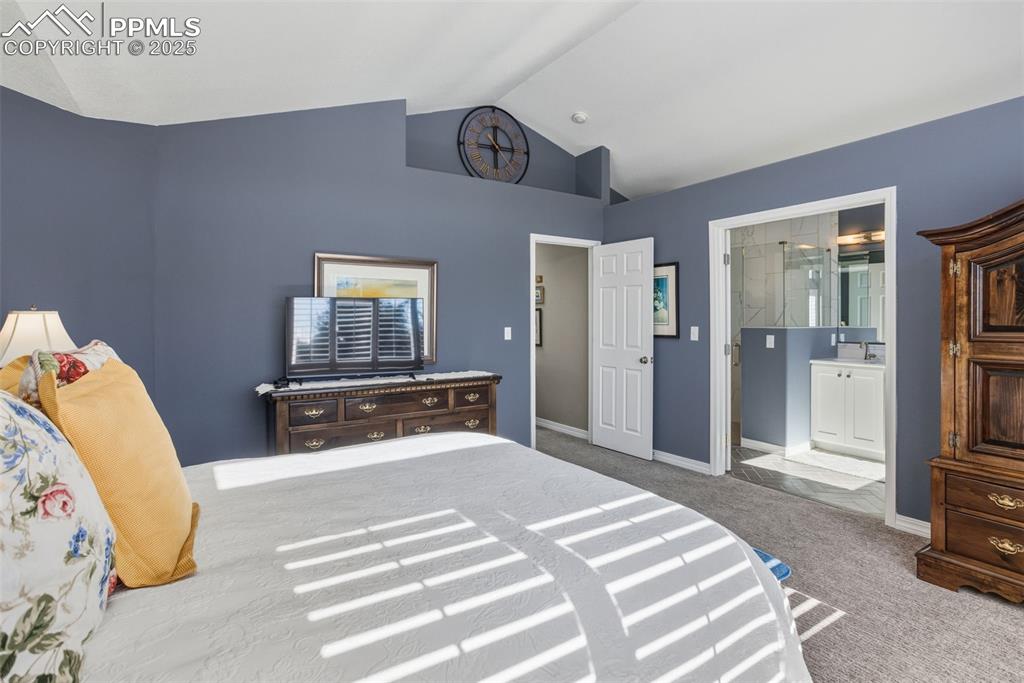 Bedroom with carpet floors and vaulted ceiling