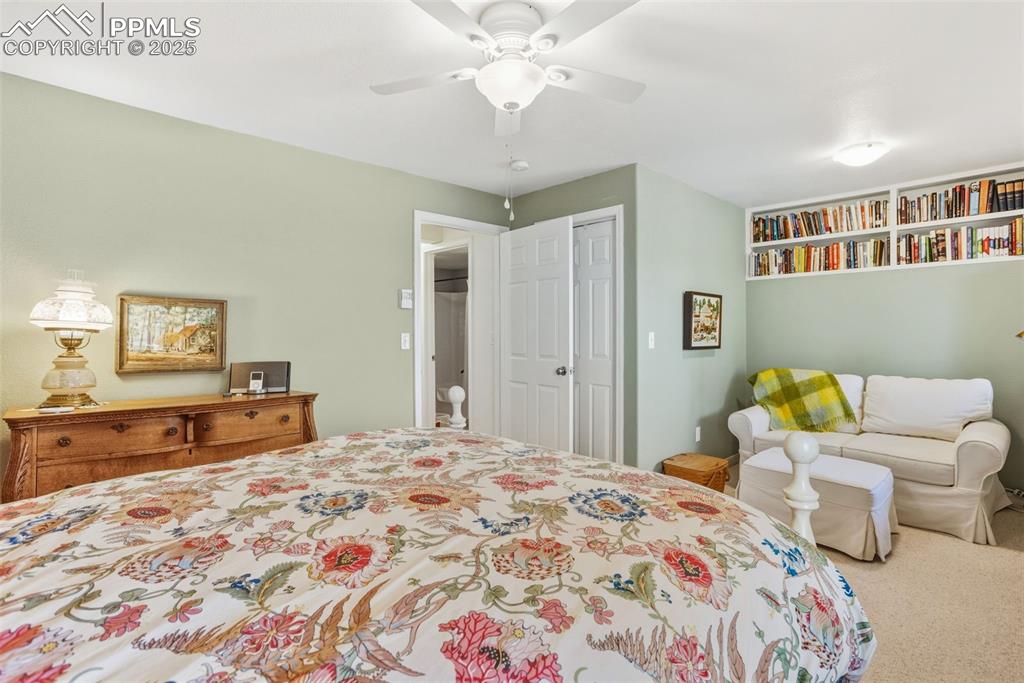 Carpeted bedroom featuring a ceiling fan