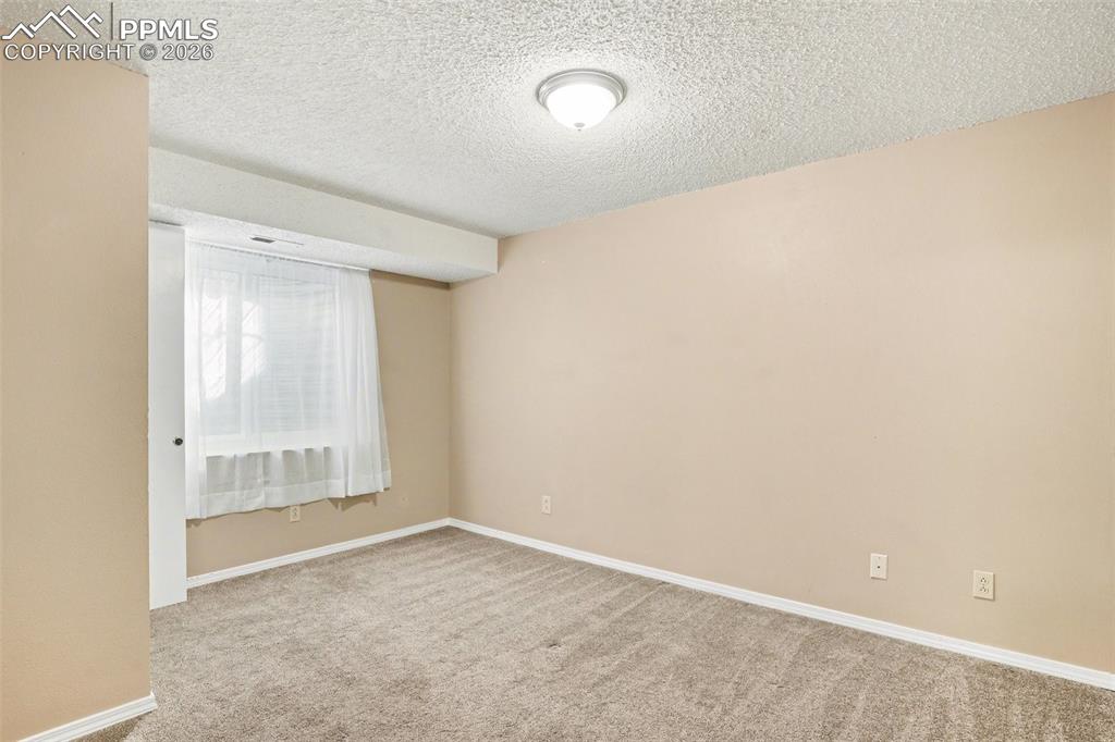 Unfurnished room with light colored carpet and a textured ceiling