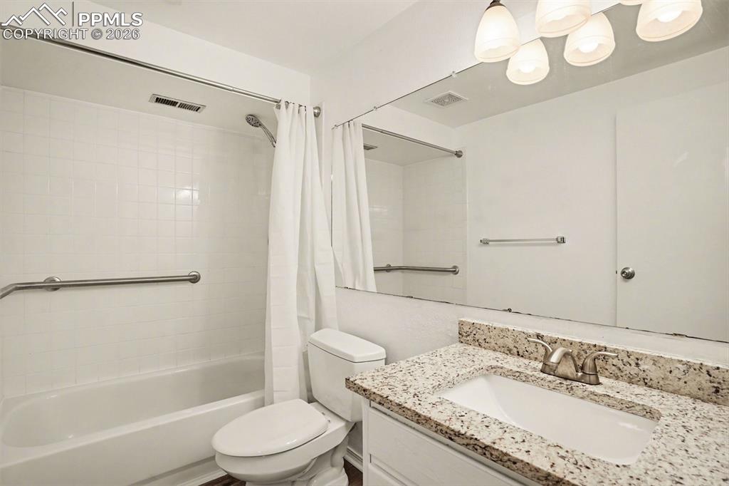 Bathroom featuring shower / bathtub combination with curtain and vanity