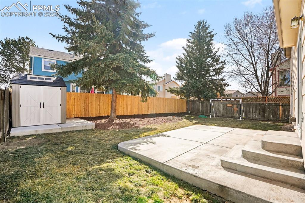 Fenced backyard with a patio and a storage shed
