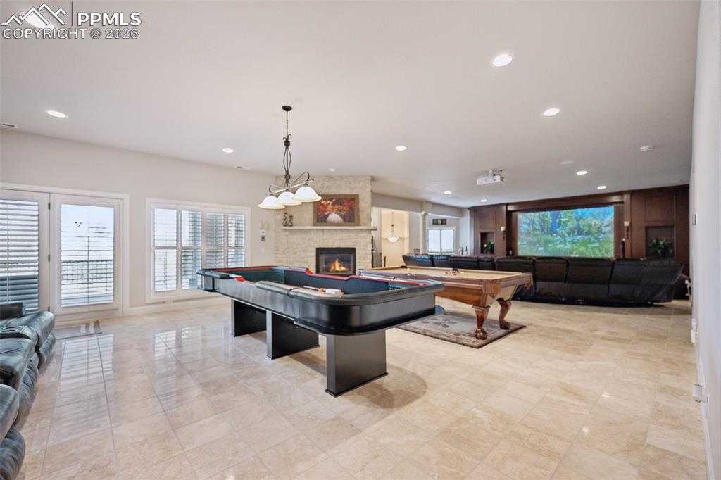 Recreation room featuring recessed lighting, pool table, and a fireplace