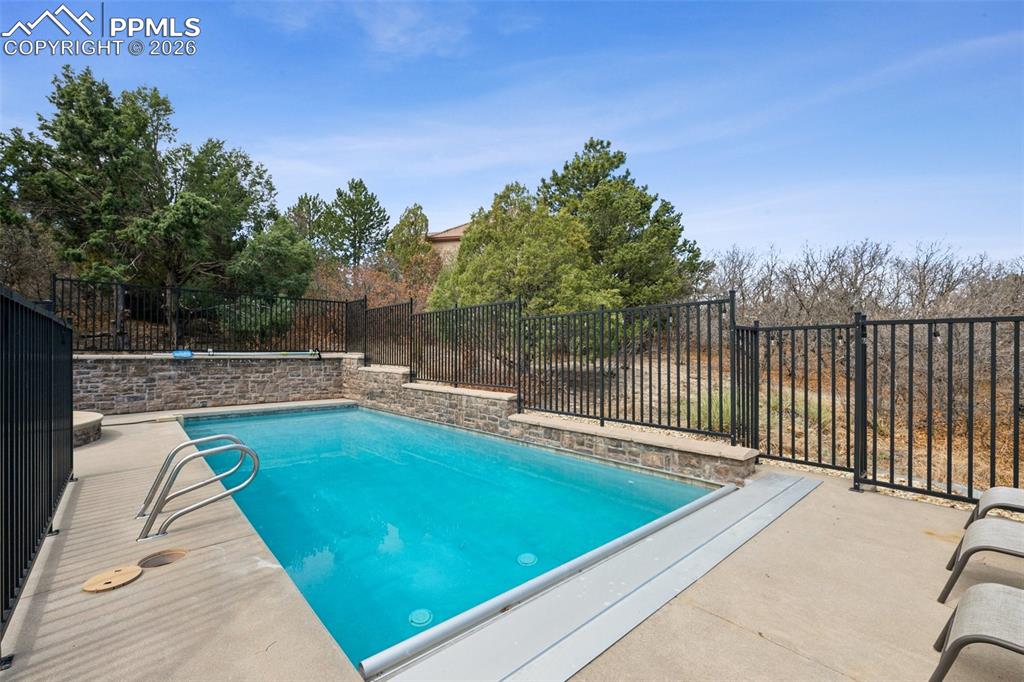 View of pool featuring a fenced backyard, a fenced in pool, and a patio