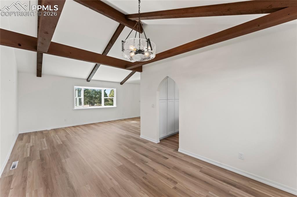 Formal dining room w/wood beams & glass chandelier