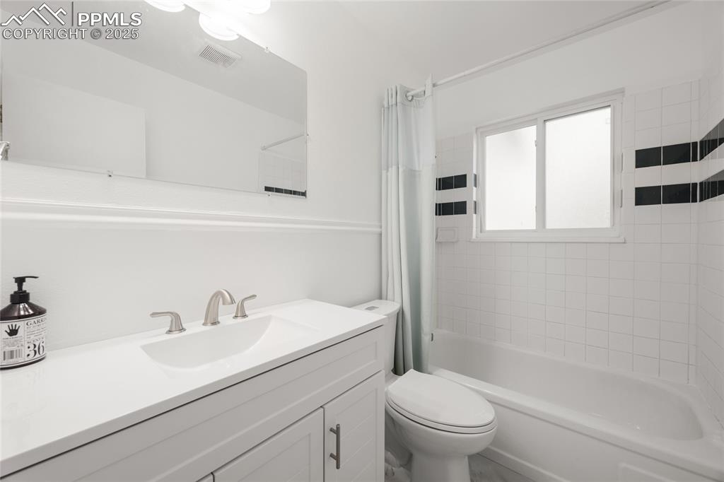 Full bathroom with shower / tub combo and vanity