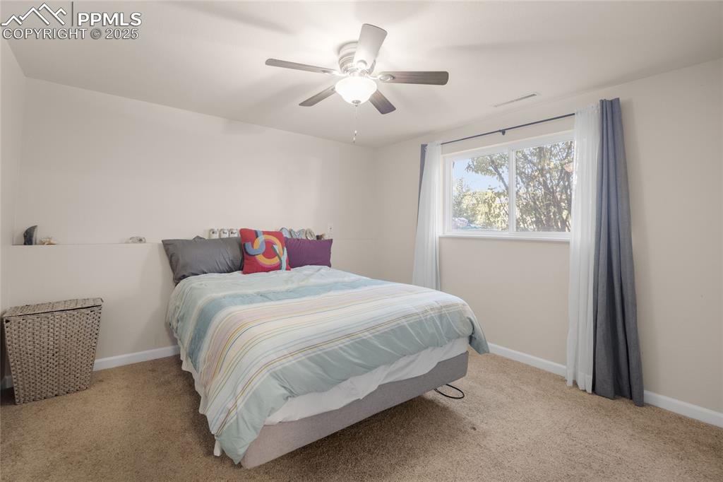 Bedroom with light carpet and ceiling fan
