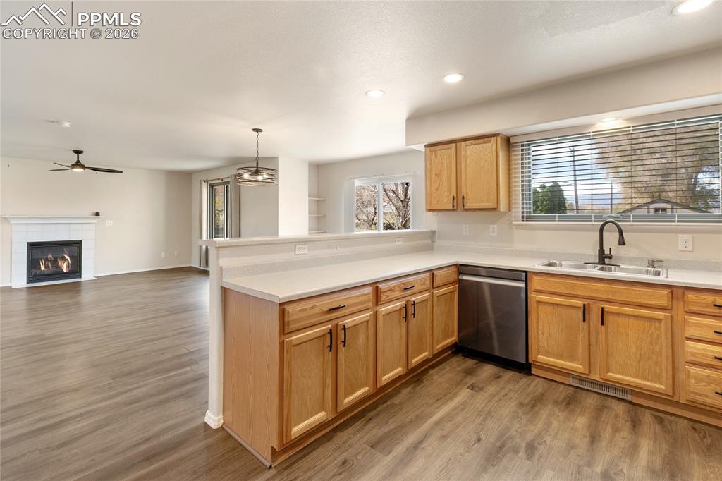 Kitchen featuring light countertops, dark wood-type flooring, a peninsula, open floor plan, and plenty of natural light