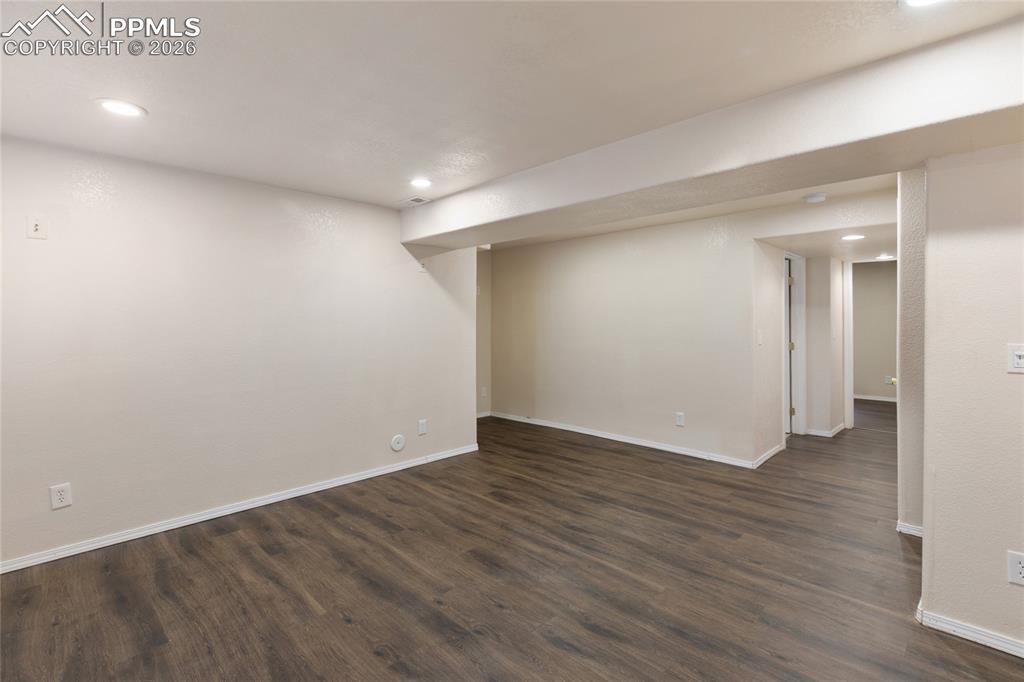 Finished below grade area with recessed lighting and dark wood-type flooring