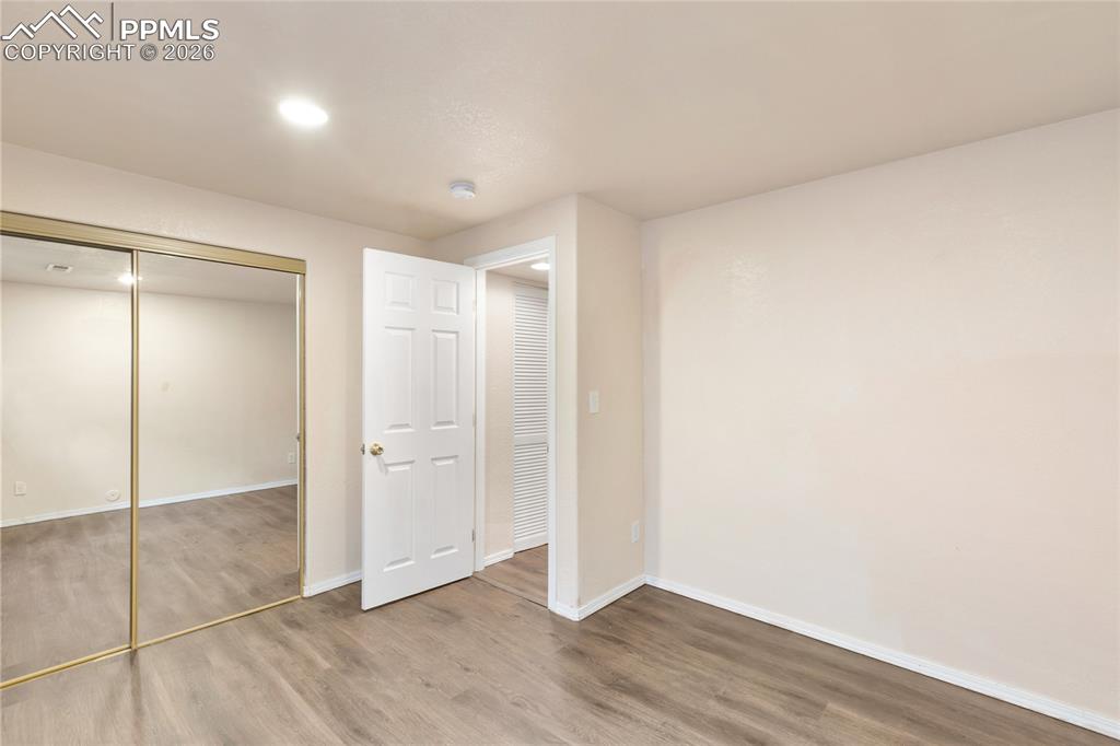 Unfurnished bedroom featuring wood finished floors and a closet