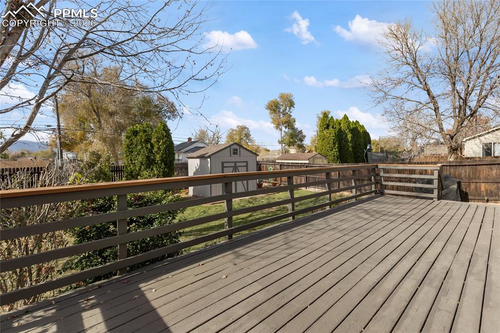 Deck with a storage unit and a fenced backyard