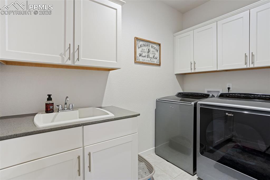 Laundry room with utility sink and cabinets for storage