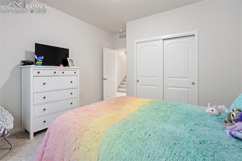 Carpeted bedroom featuring a closet