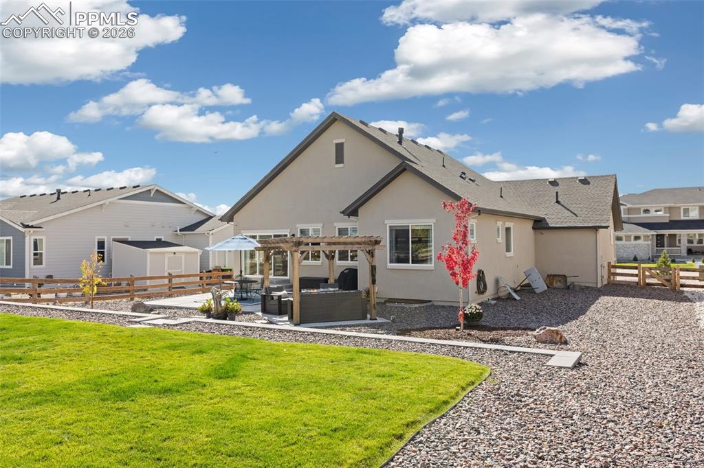 Back of house featuring a fenced backyard, a patio area, stucco siding, outdoor furniture, and a pergola