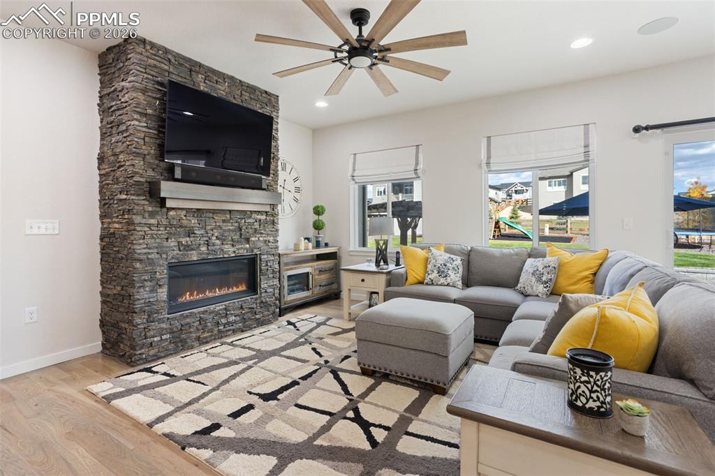 Main level living room with liner gas fireplace and floor to ceiling stone