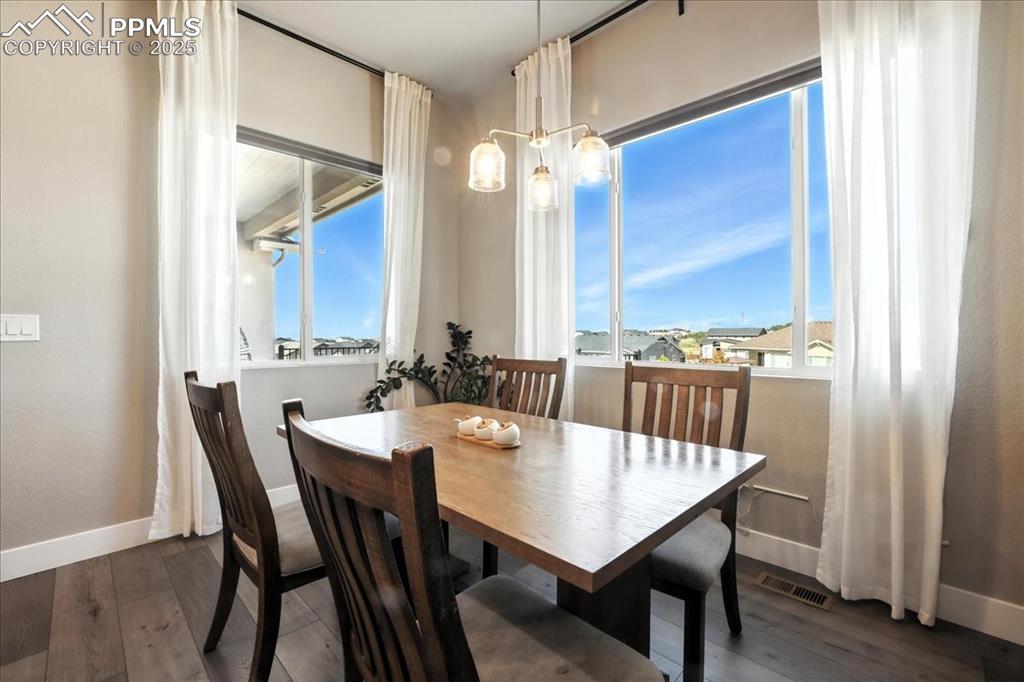 Dining room with wood finished floors and a chandelier