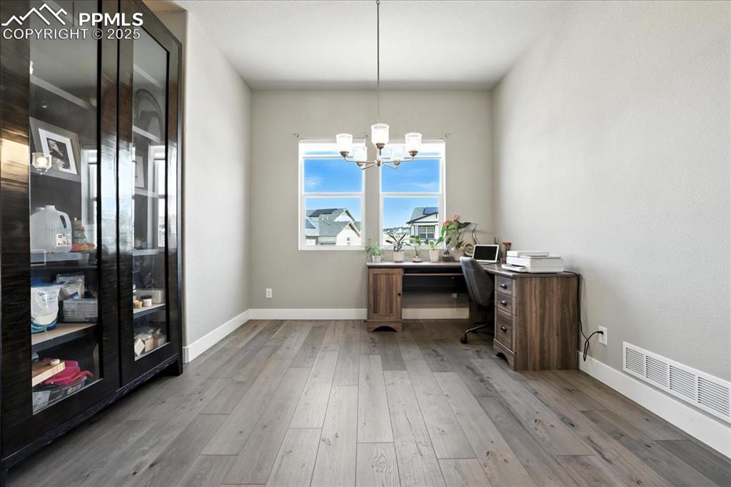 Office area featuring wood finished floors and a chandelier