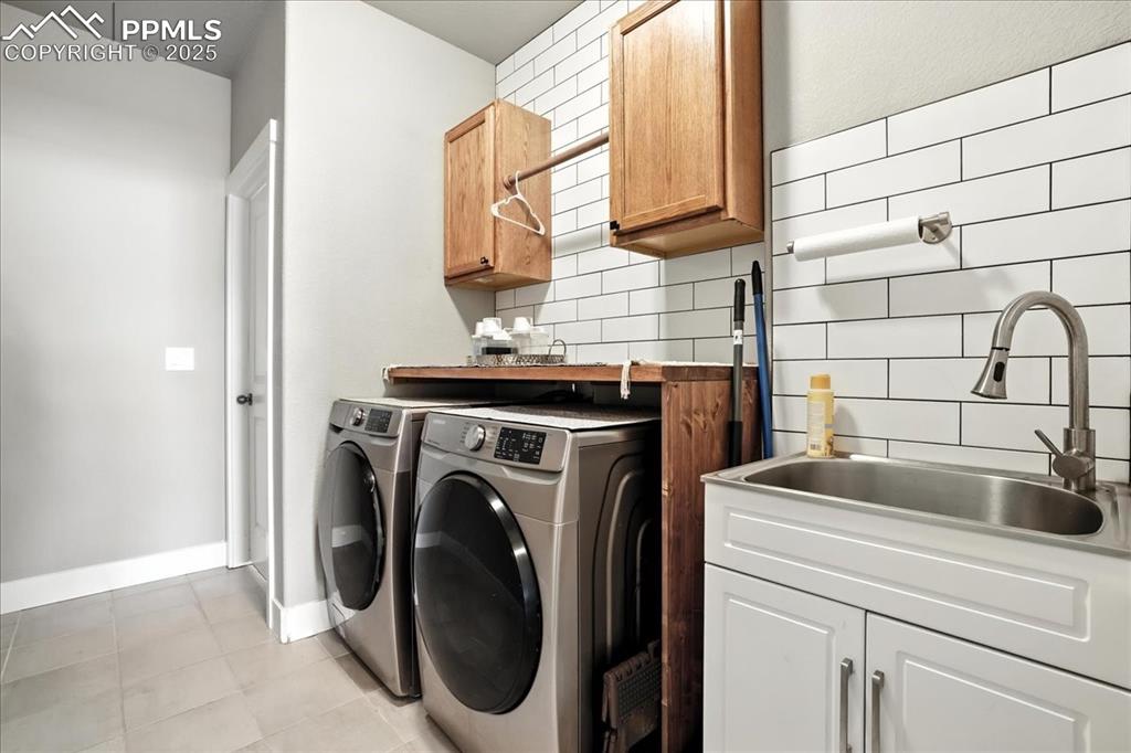 Laundry room with cabinet space, independent washer and dryer, and light tile patterned floors