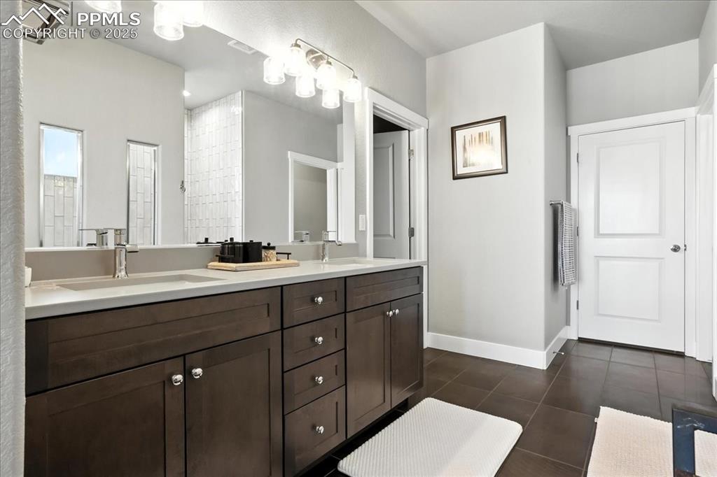 Full bath with double vanity and tile patterned flooring