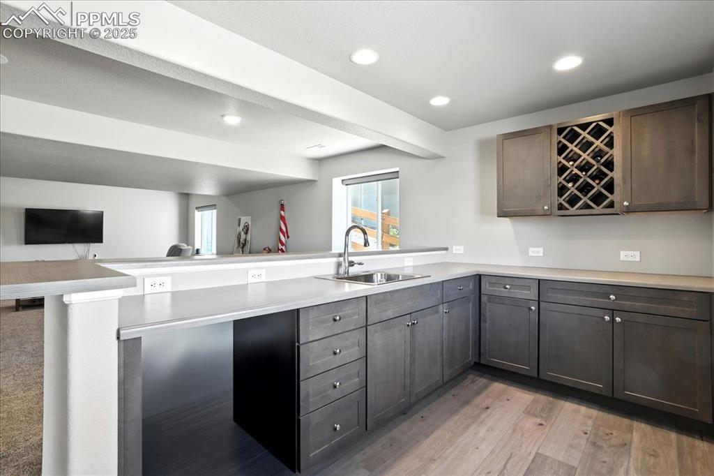 Kitchen with a peninsula, recessed lighting, open floor plan, light countertops, and light wood-type flooring