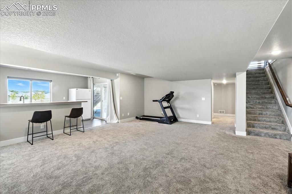 Exercise area with a textured ceiling and carpet floors