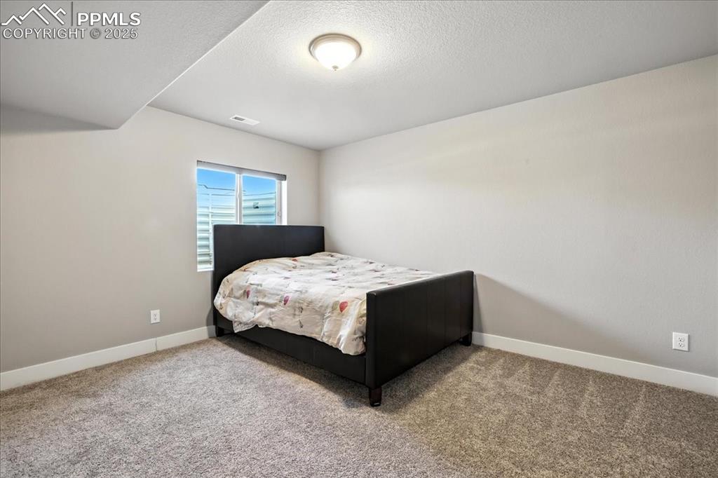 Bedroom featuring carpet and a textured ceiling