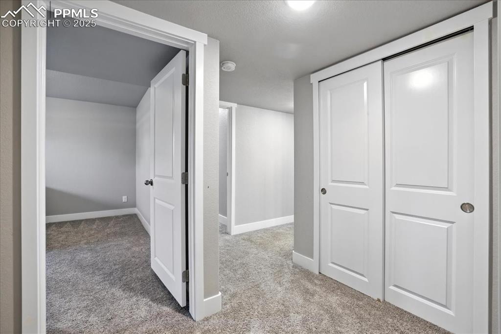 Hall featuring carpet floors and a textured ceiling